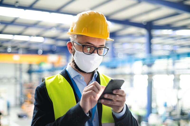 Worker using phone to connect through FSM Connect Your team and field digitally